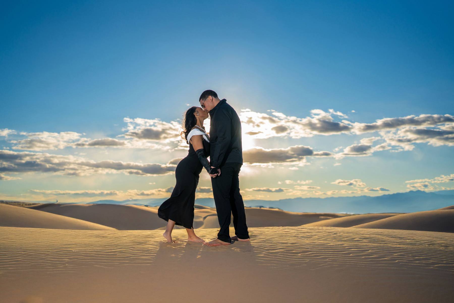 Couple on the sand dunes at sunset
